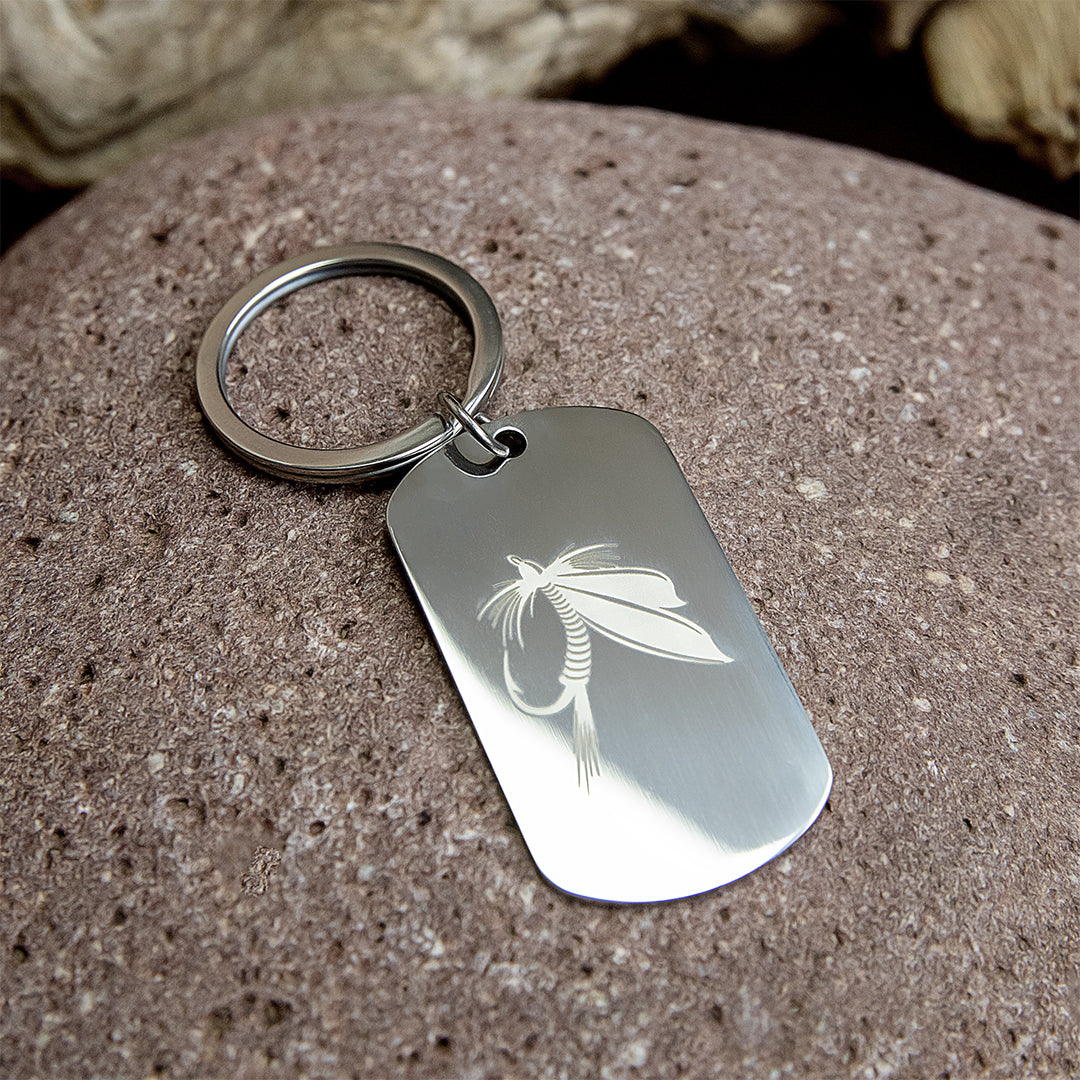 Stainless steel dog tag keychain with engraved fly fishing designs.