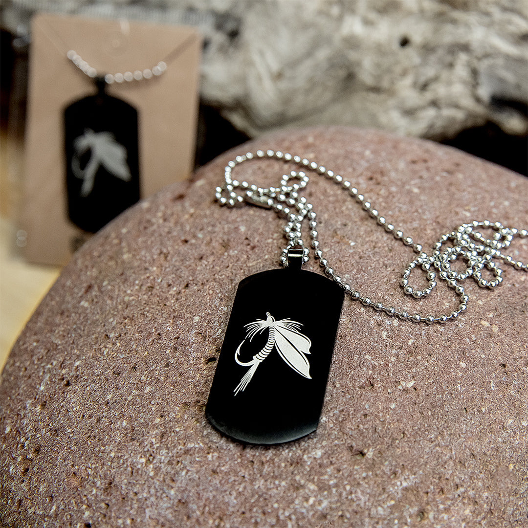 Black stainless steel dog tag military pendant with engraved design on a silver chain.